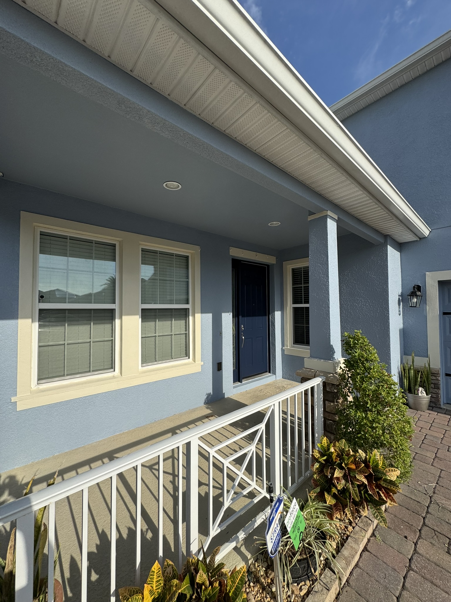 Repainted front porch with blue stucco and a navy entry door