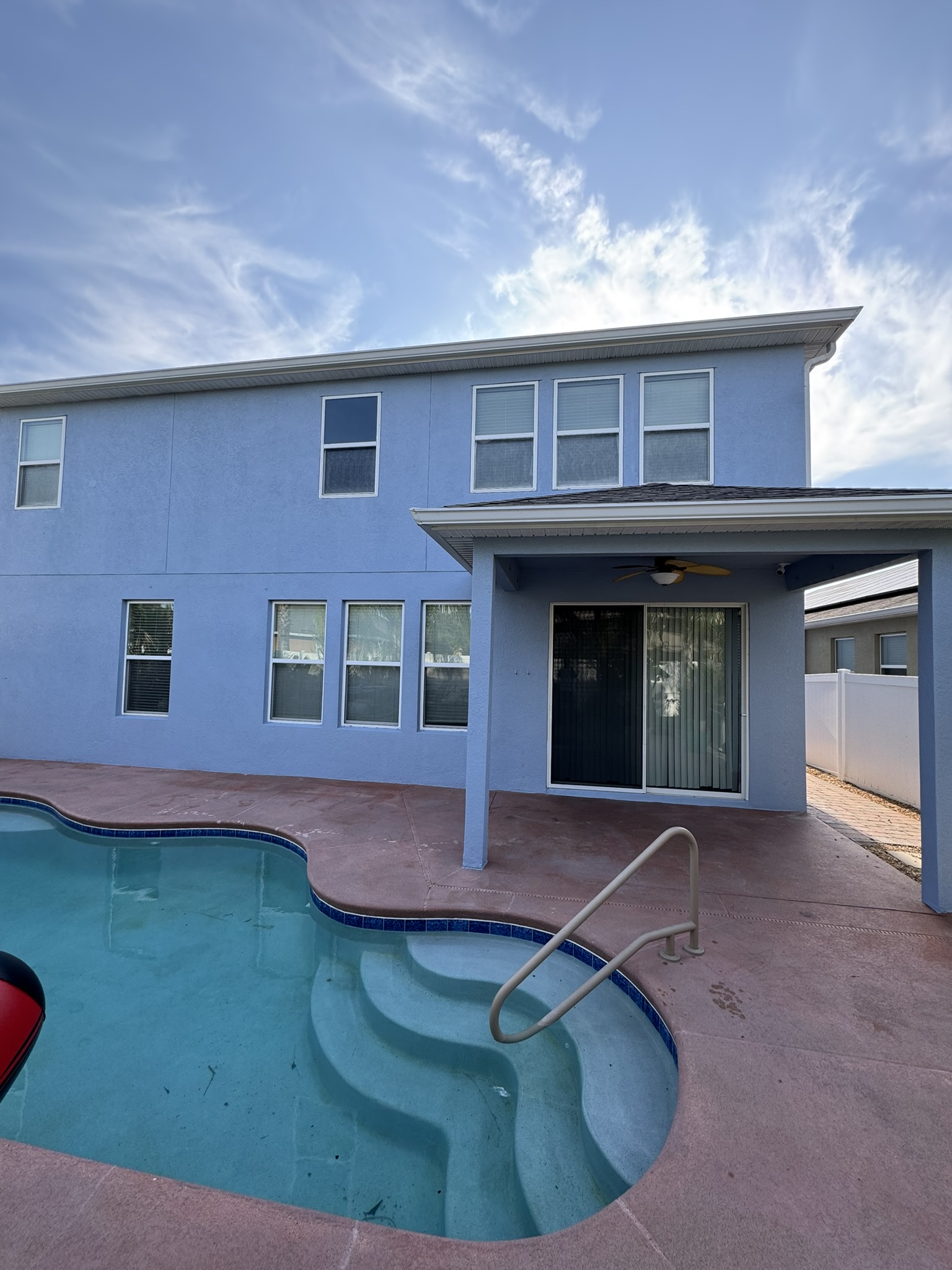 Two-story residential exterior repaint with a pool